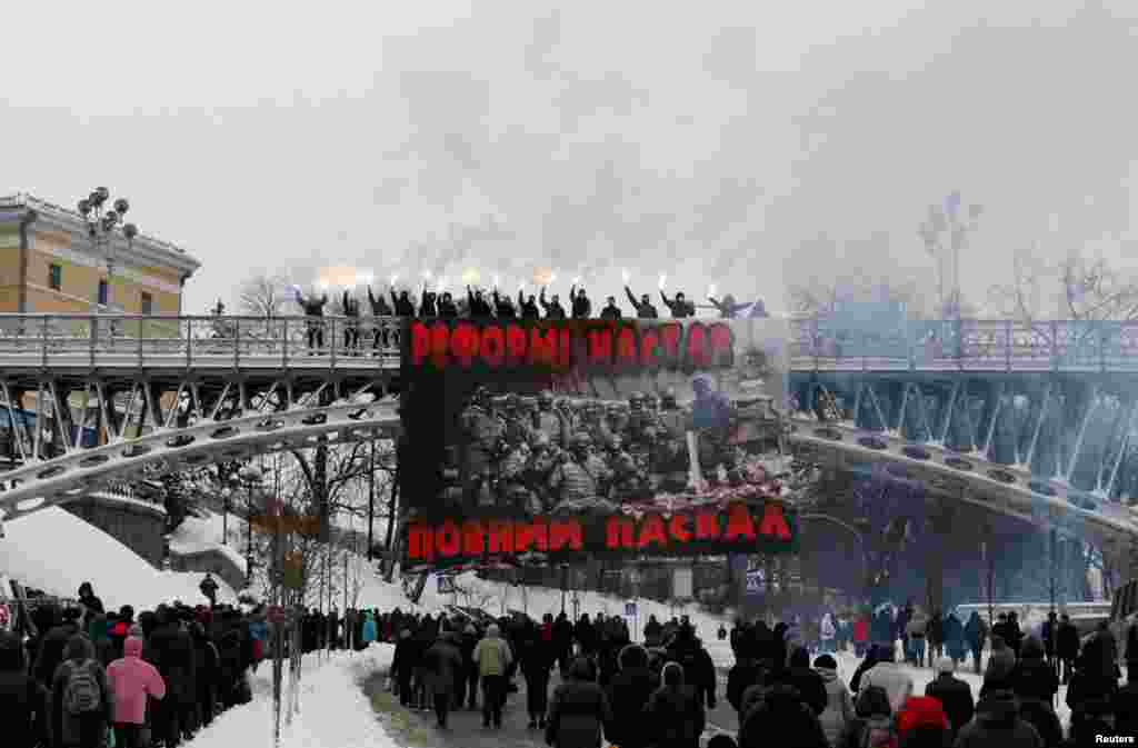 Активисты держат горящие факелы во время акции протеста против расширения полномочий полиции и власти в центре Киева, 14 ноября (Reuters/Valentyn Ogirenko)