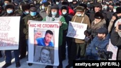 На митинге в Уральске протестующий держит плакат "Назарбаев - диктатор". 28 февраля 2021 года.