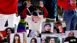 An activist takes part in a flash mob with photographs of women imprisoned since the presidential election on August 9, 2020, as they protest against police violence in Minsk on February 14.