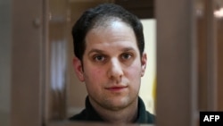 U.S. journalist Evan Gershkovich, arrested on espionage charges, looks out from a defendants' cage before a hearing to consider an appeal at the Moscow City Court in Moscow on February 20.