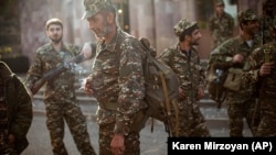 Ethnic Armenian volunteers gather at a center where they receive their uniforms and weapons before being dispatched to the front line near Hadrut in Nagorno-Karabakh.