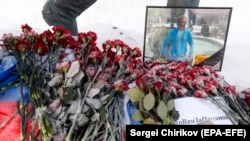 Red carnations are placed beside a photo of Russian pilot Roman Filipov, who was shot down in Syria, in front of the Russian Defense Ministry in Moscow on February 6. 