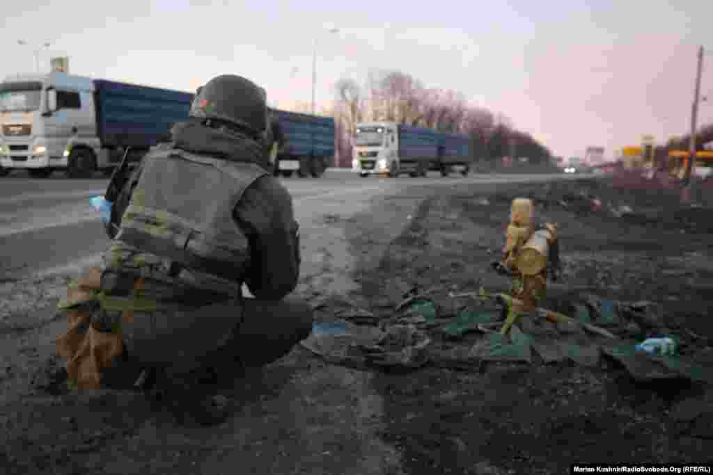 A Ukrainian soldier crouches next to an anti-tank missile on the outskirts of Kharkiv.&nbsp;