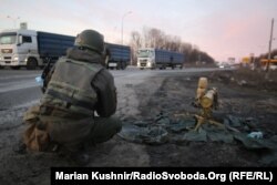 A Ukrainian soldier crouches next to an anti-tank missile at the scene of a battle on the outskirts of Kharkiv.