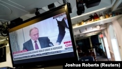 Ruski predsednik Vladimir Putin na ekranu u sali za medije u Beloj kući tokom TV prenosa potpisivanja nezavisnosti separatističkih regija na istoku Ukrajine, 21. februar 2022. 