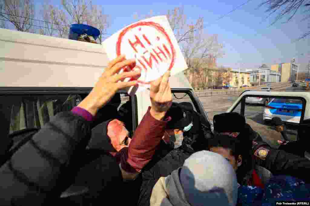 Сотрудник полиции вырывает из рук активистки плакатик с надписью: «Ні війні» (с украинского — «Нет войне!»)