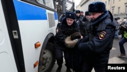 Police detain a protester during a rally near the Russian Defense Ministry headquarters in Moscow.