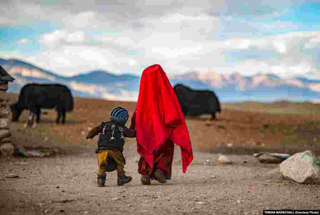 Pamir Kyrgyz children at their nomadic camp in Afghanistan’s Pamir Mountains. The boy’s back is pinned with talismans in the belief they will protect his health in a land with rare access to medical care. 