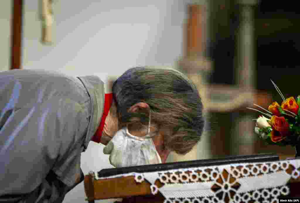 A worshiper wearing a face mask kisses an icon during the Orthodox Christian Easter service at a church in Zenica, central Bosnia.