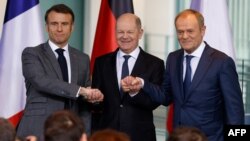 French President Emmanuel Macron, German Chancellor Olaf Scholz, and Polish Prime Minister Donald Tusk pose at a press conference in Berlin on March 15.