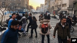 People are affected by tear gas fired by Iranian riot police to disperse protesters in Tehran on December 30. Since the protests erupted last week, the government has been blocking social media websites to disrupt the spread of information about the demonstrations.