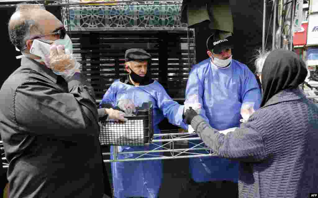 People wait in Tehran for prevention packages.