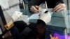 Bosanski granični policajac pomaže putniku da ispuni upitnik o zdravstvenom stanju na aerodromu u Sarajevu, mart 2020. godine