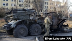  Український військовослужбовець проходить повз знищену російську реактивну систему залпового вогню «Град». Харків, 24 березня 2022 року