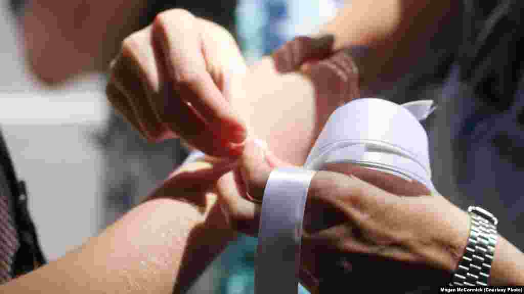 Marchers in New York tied white ribbons on each other's wrists, echoing ongoing Russian protests against government repression.