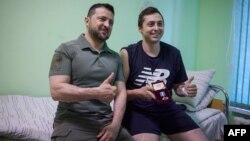 A handout photograph taken and released by the Ukrainian Presidential Press Service on July 2, showing Ukrainian President Volodymyr Zelenskiy posing for a photo with a Naval serviceman at a military hospital in Odesa.
