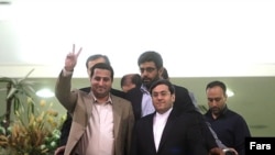Shahram Amiri, gesturing, with Iranian authorities after his return to Tehran on July 15.