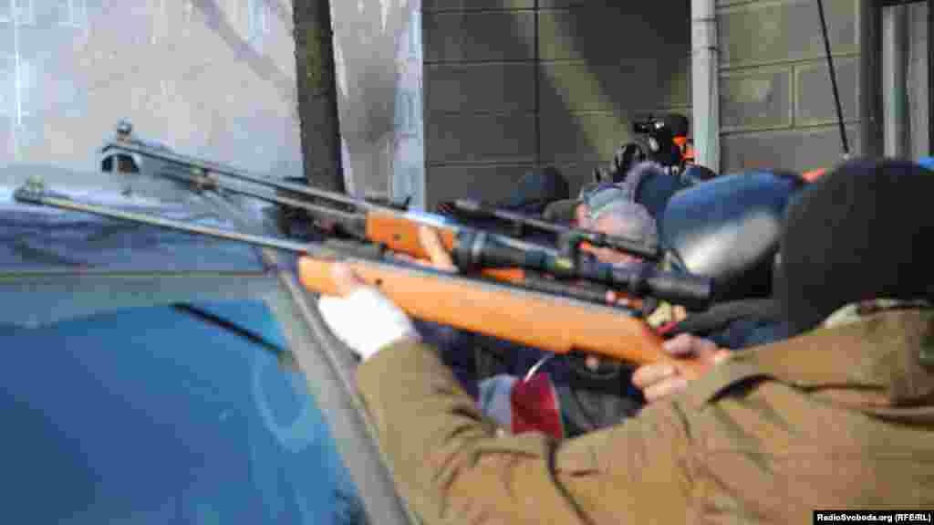 Protesters aim weapons in Kyiv's government district on February 18.