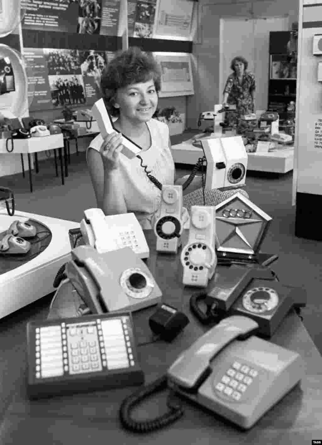 A woman displays products and a State Quality Mark of the U.S.S.R., the highest certification of quality, in the shop at the Perm telephone production plant in 1982.