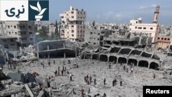 یوشمېر فلسطینیان د غزې پر یو ښوونځي، چې پکې بې کوره وګړي اوسېدل، د اسراییلو تر برید وروسته ړنګه وداني ګوري - د اپرېل څلورمې انځور.