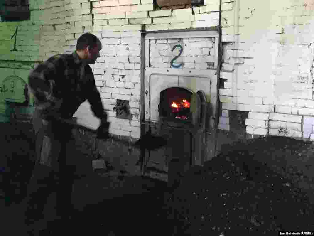 A worker shovels coal in the furnace room. According to the new museum’s director, this is where Soviet dissident and veteran rights activist Sergei Kovalyov worked when he served at Perm-36.