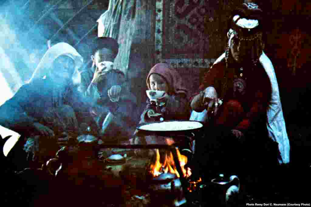 An archival photo of a nomadic family gathered around the fire