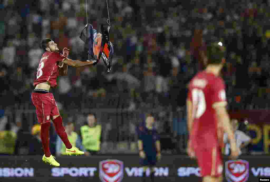 After the drone swooped very low over the players, Serbian defender Stefan Mitrovic leaped up and ripped the flag down.