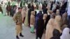 Women in Quetta wait their turn to cast their ballots at a polling station in the country' parliamentary elections on February 8. 