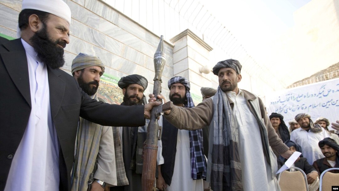  A Taliban militant hands over his weapons in Herat. Can the new incentives persuade more insurgents to lay down their arms? 