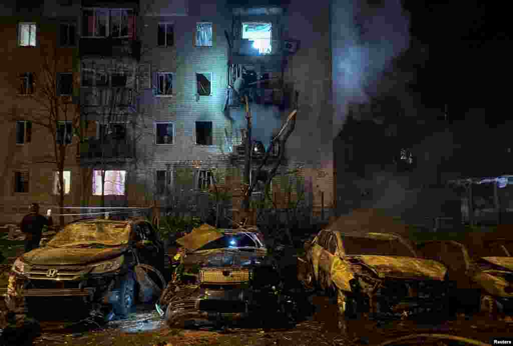Вид на разрушенные автомобили и жилой дом, повреждённый ударом российского беспилотника. Харьков, Украина, 3 апреля 2025 года. REUTERS/Sofiia Gatilova.