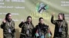 Cele patru tinere - soldat din armata israeliană pe scena în care au fost prezentate de militanții palestinieni Hamas, înainte de a fi preluate de israelieni.