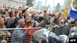 Police try to prevent angry protesters - mainly war veterans - from storming the federal parliament building.