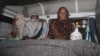 Relatives sit beside the body of Farzana Iqbal (nee Parveen), who was stoned to death by members of her family for marrying against their wishes, in Lahore on May 27.