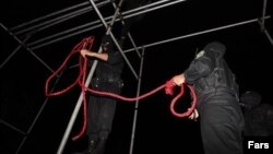 Iranian police officers prepare a hanging rope.
