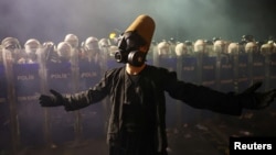 Demonstrant nosi dervišku odjeću i gas masku, gestikulira pored policije tokom protesta na dan kada je gradonačelnik Istanbula Ekrem Imamoglu zatvoren u sklopu istrage o korupciji, Istanbul, Turska, 23. mart 2025.