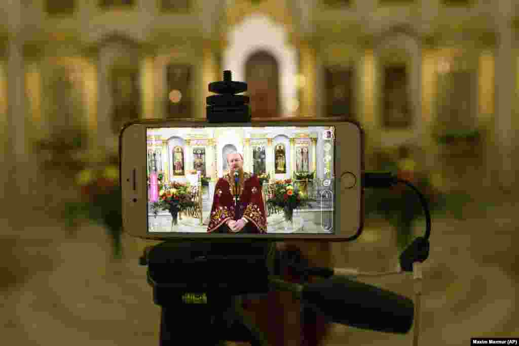 A Russian Orthodox priest speaks to parishioners during a live broadcast in an empty Moscow church on April 19. Just a few priests accompanied by volunteers conducted the religious service.