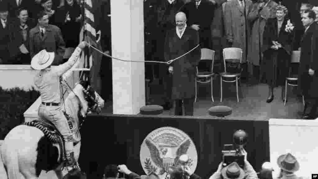 Kauboj Montie Montana izaziva smijeh okupljenih gostiju dok lasom hvata predsjednika Dwighta D. Eisenhowera tokom predsjedničke inauguracijske parade 20. januara 1953. godine. Eisenhower je služio dva puna mandata. 