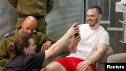 Andrei Kozlov speaks to relatives shortly after his rescue on June 7.