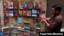 په پېښور کې د زړو کتابونو په دوکان کې یو کس له کتابه ګرد پاکوي ـ پخوانی انځور