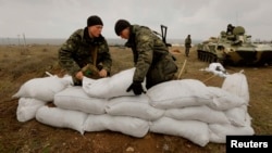 Ukrainian soldiers fortify a position with sandbags at a Ukrainian Army military camp set up close to the Russian border in east Ukraine on March 20.
